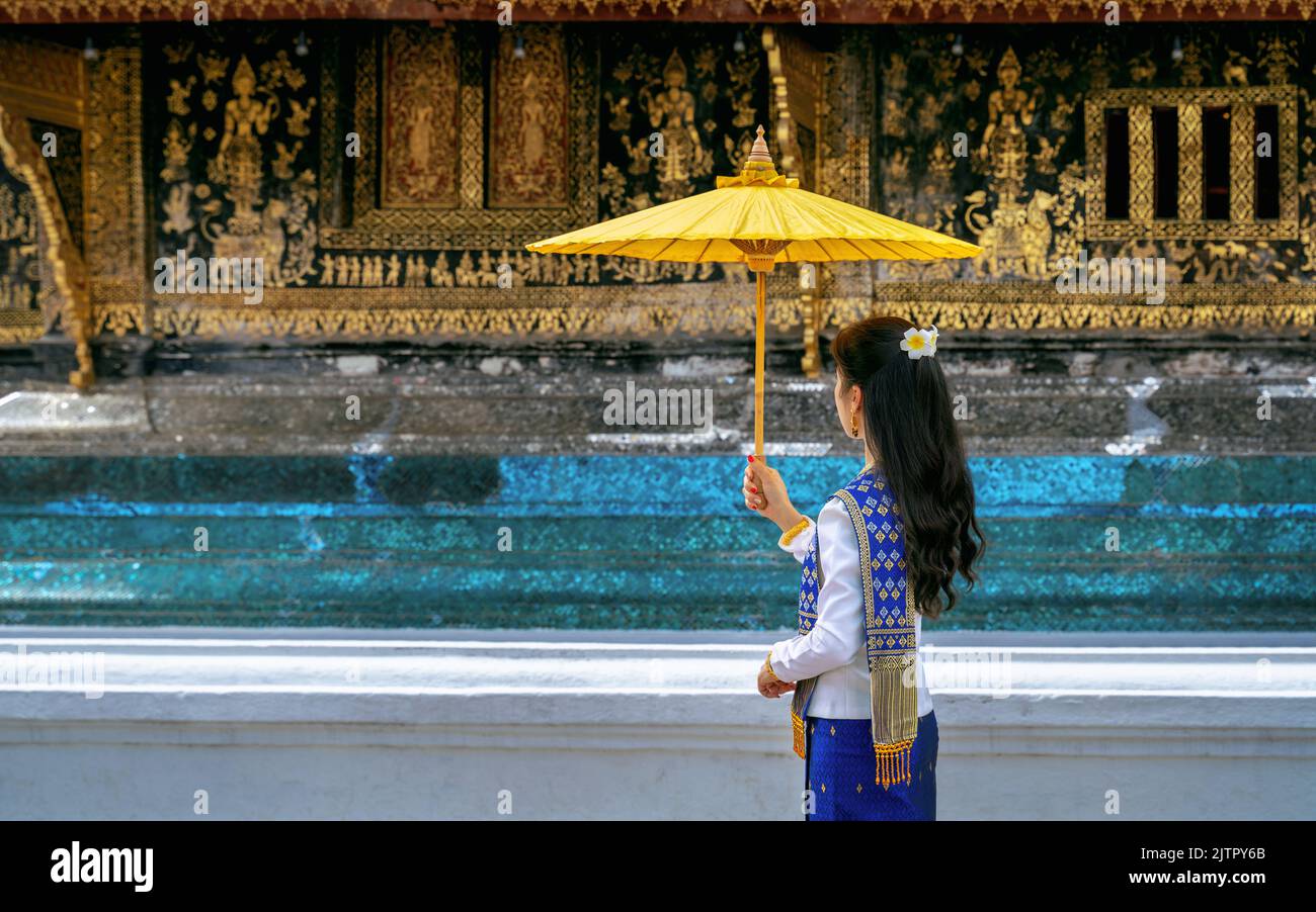 Asiatische Frau, die laos traditionell trägt, im Wat Xieng Thong (Tempel der Goldenen Stadt) in Luang Prabang, Laos. Stockfoto