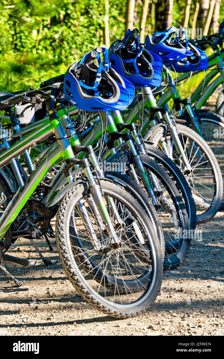 Verleih von Fahrrädern und Helmen, die für eine Abenteuertour bereit sind Stockfoto