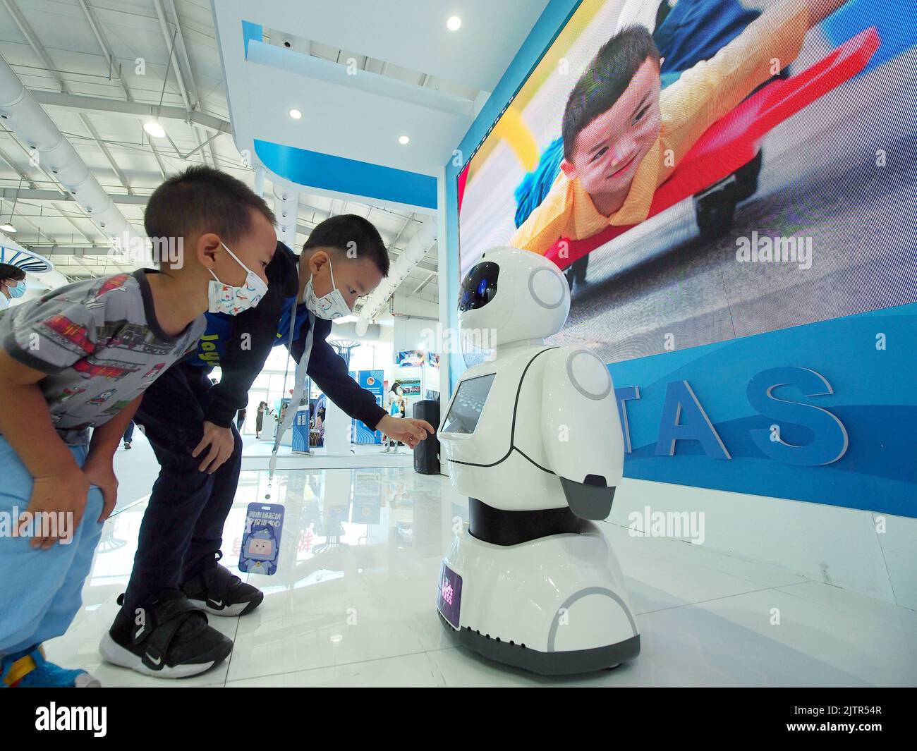 PEKING, CHINA - 1. SEPTEMBER 2022 - zwei Kinder interagieren mit einem Lernroboter im Education Service Pavilion der Shougang Garden Exhibiti Stockfoto