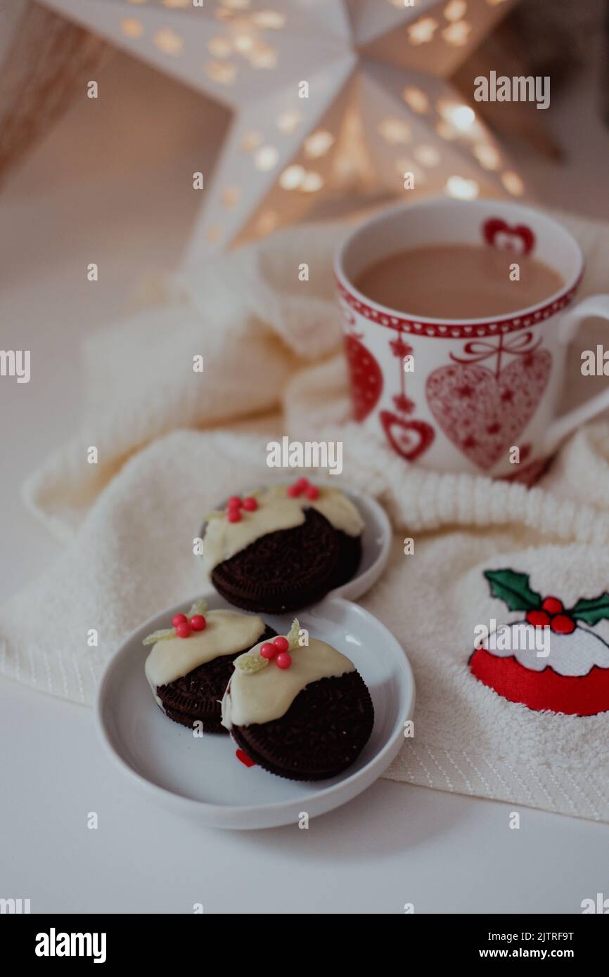Schokoladenkekse in weiße Schokolade getaucht und mit Süßigkeiten/Süßigkeiten gekrönt, um kleine Weihnachts-Puddings zu kreieren. Stockfoto