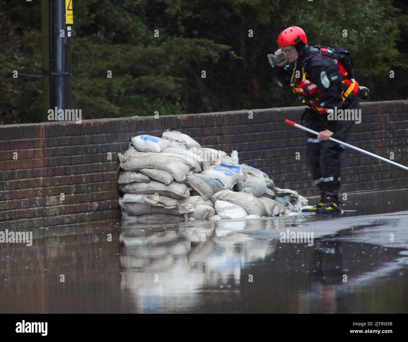 SANDSÄCKE BEDECKEN EINEN RISS IN DER WAND, WÄHREND DER FLUSS WALLINGTON DROHT, SEINE UFER ZU SPRENGEN UND DAS DORF WALLINGTON IN DER NÄHE VON FAREHAM, HANTS, ZU ÜBERFLUTEN. BILDER VON MIKE WALKER, MIKE WALKER, 2012 Stockfoto