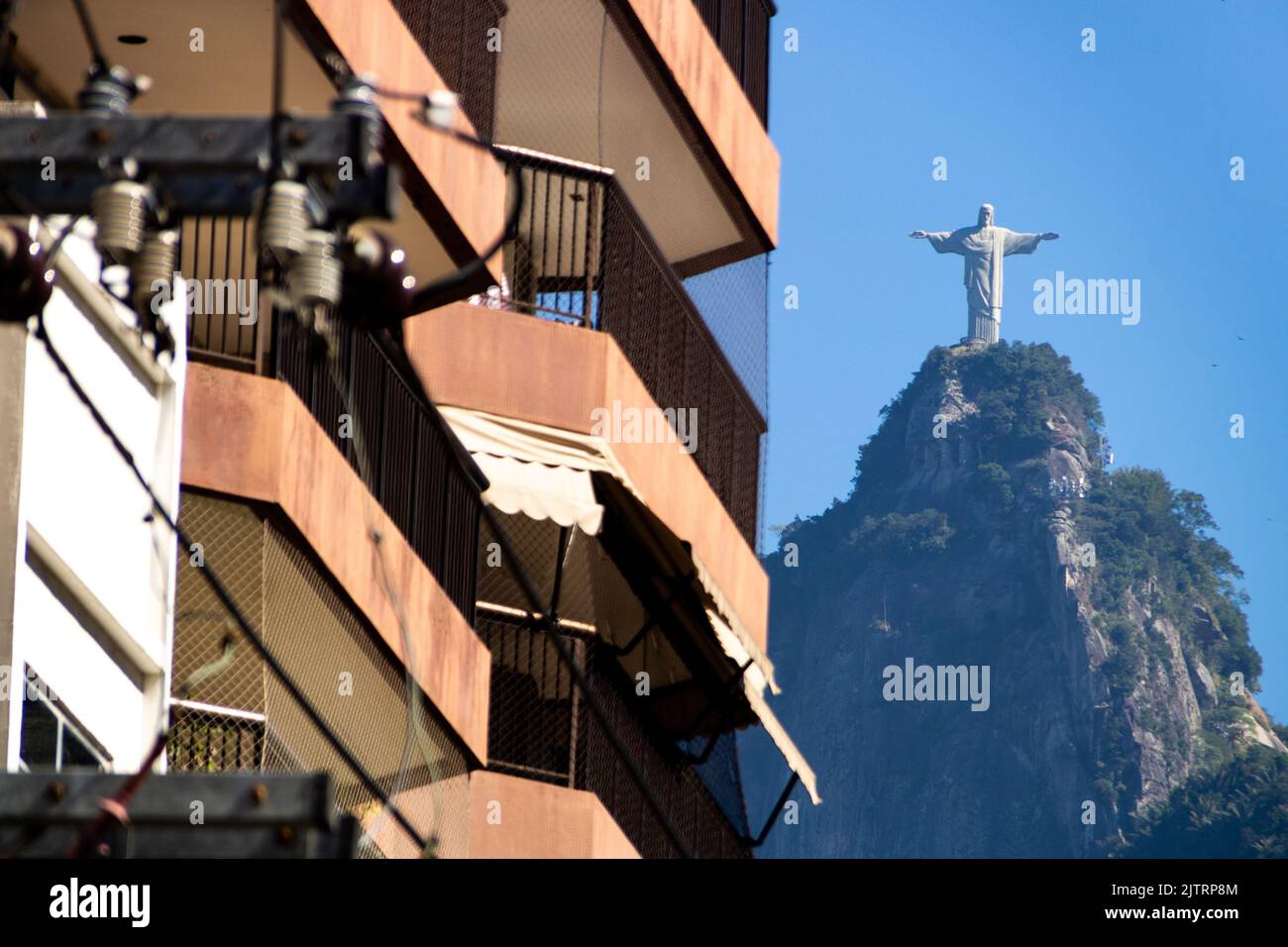 Balkon eines Gebäudes mit schwarzem Schutzschirm und der Christus-Erlöser-Statue im Hintergrund in Rio de Janeiro, Brasilien - 22. Juni 2020: bal Stockfoto