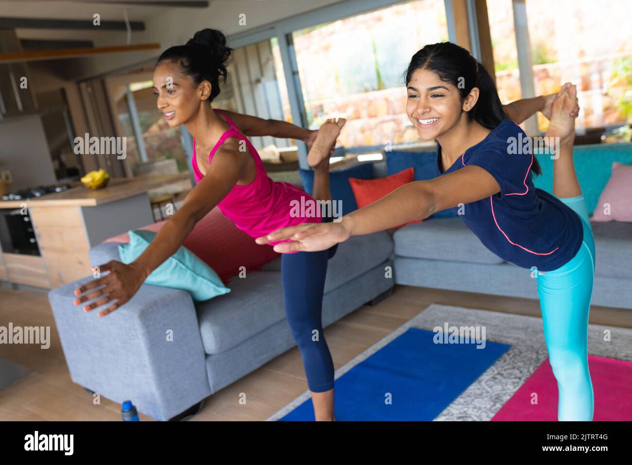 Lächelnde biracial Mutter und Tochter üben Tänzerin posieren Yoga zu Hause Stockfoto