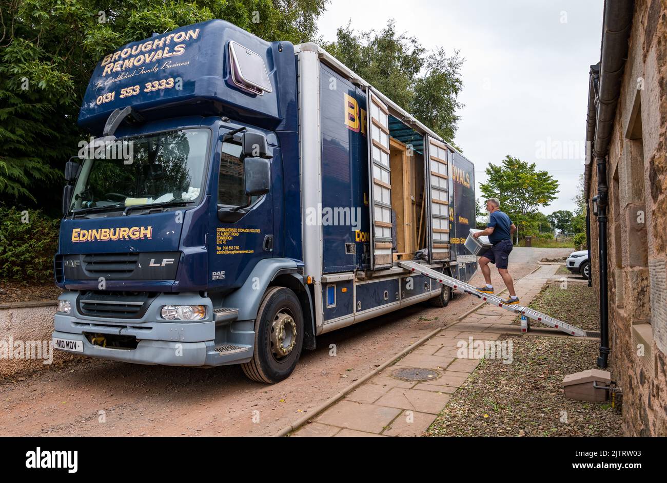 Mann, der Haus mit Broughton Removals LKW-Containerlagerung verpackt und umzieht, Schottland, Großbritannien Stockfoto