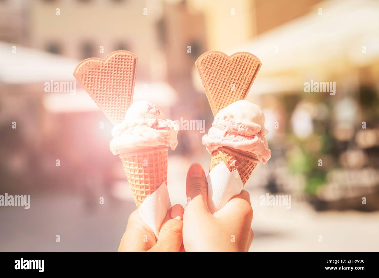 Leckeres Eis in den Händen. Verschwommener Hintergrund des Sommerstadtcafés Stockfoto