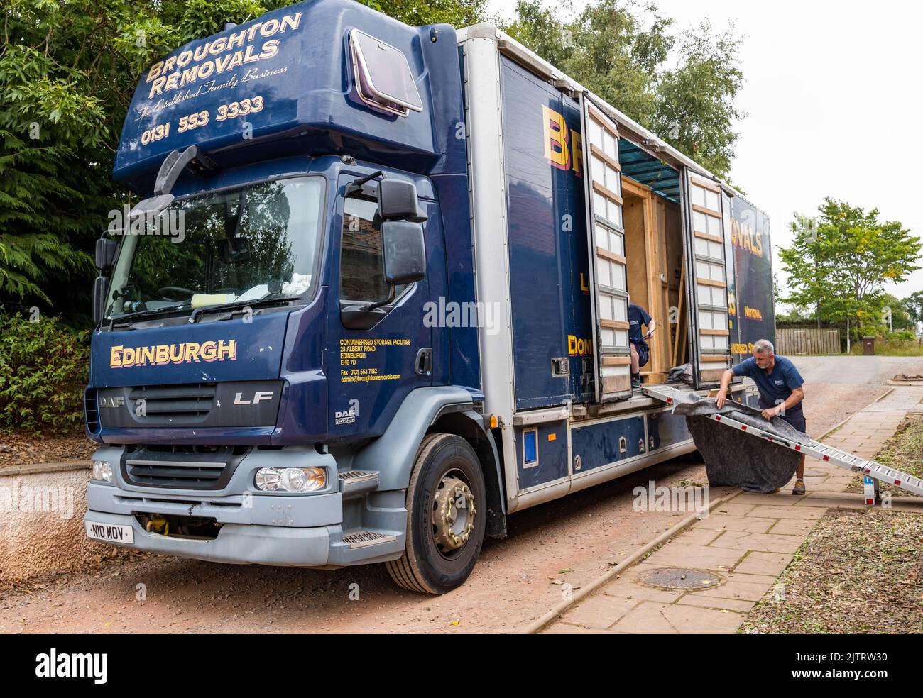 Mann, der Haus mit Broughton Removals LKW-Containerlagerung verpackt und umzieht, Schottland, Großbritannien Stockfoto