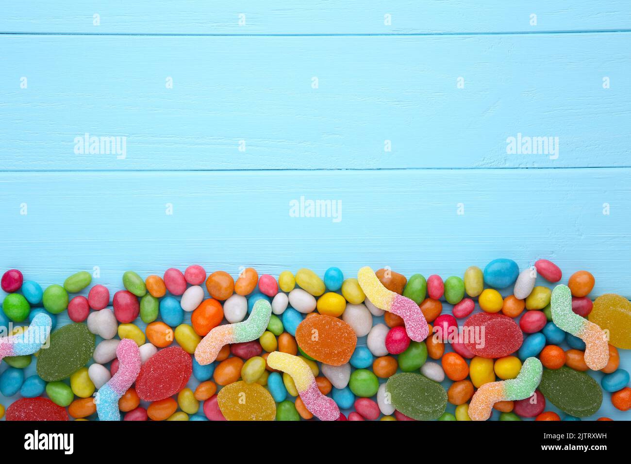 Gemischte Mischung aus verschiedenen Bonbons und Gelees auf Blau Stockfoto