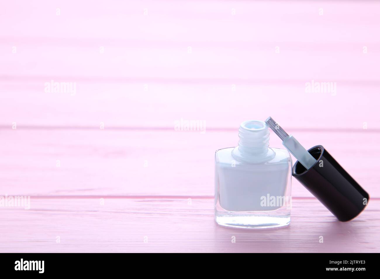 Weißer Nagellack auf rosafarbenem Holzbckground, Makro Stockfoto