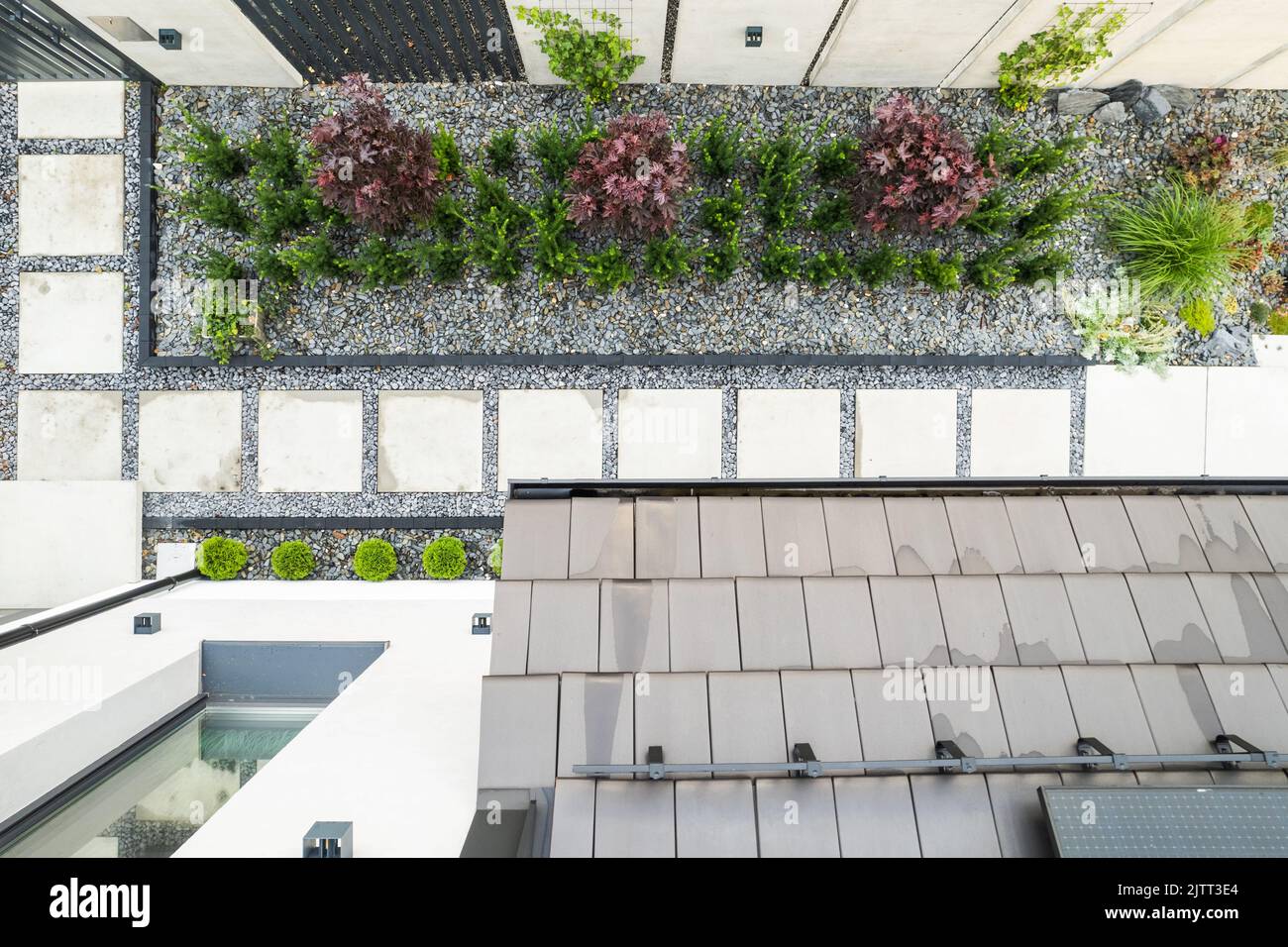 Blick von oben auf die landschaftlich gestaltete Zaun Linie auf dem vorderen Hof des privaten Wohnhauses mit Garten Kieselsteine und gefliesten Pfad dekoriert. Haus Umgebung Desi Stockfoto