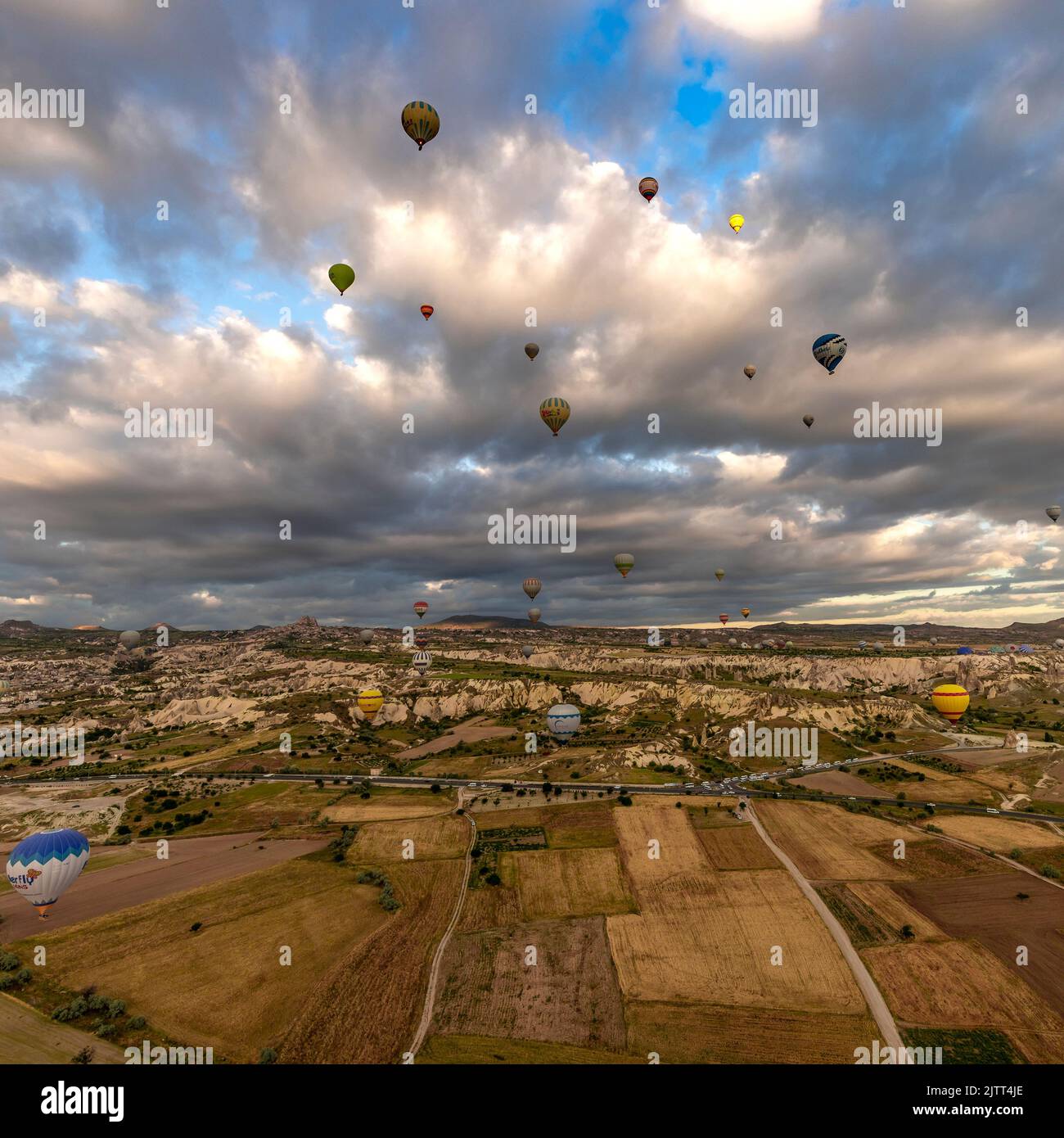 GOREME/TÜRKEI - 26. Juni 2022: Bunte Heißluftballons fliegen bei Sonnenaufgang in der Nähe von goreme, Luftaufnahme Stockfoto