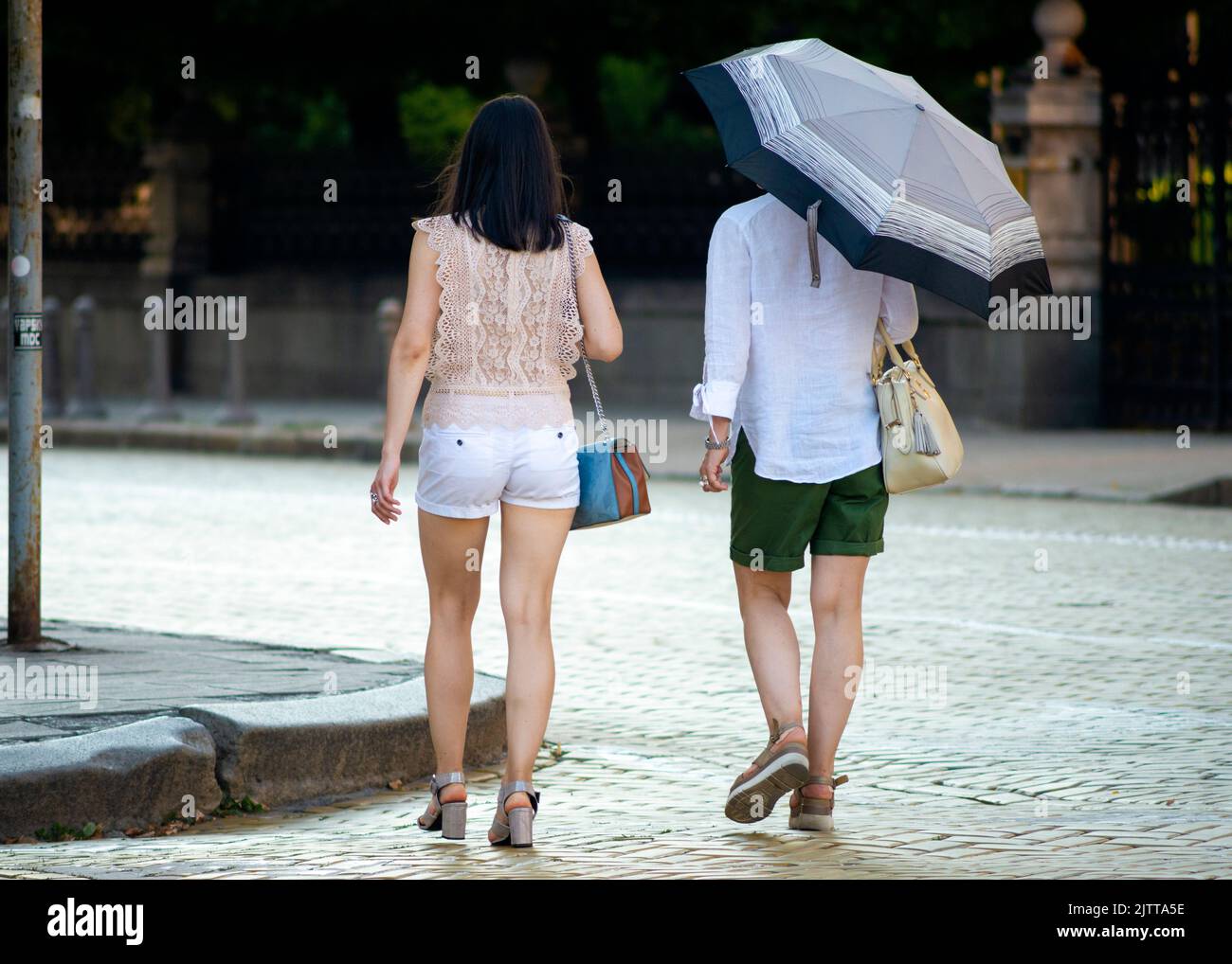 Asiatische weibliche Touristen mit Regenschirm zu Fuß auf gelben Kopfsteinpflaster gepflasterten Zar Osvoboditel Straße in der Innenstadt von Sofia, Bulgarien, Osteuropa, Balkan, Stockfoto