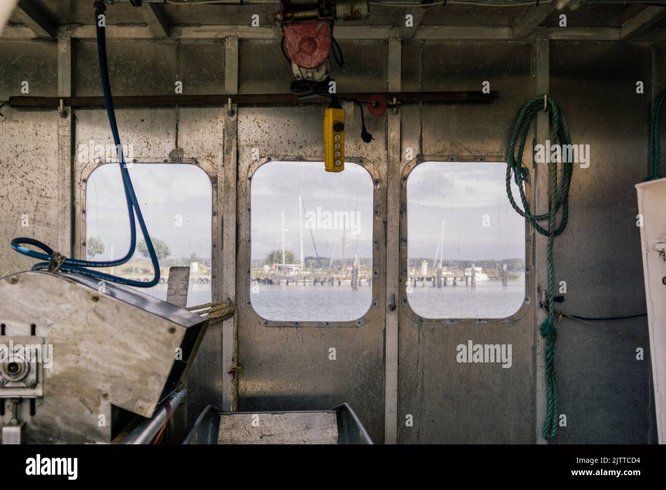 Blick durch das Fenster eines Fischerbootes auf dem Wasser und Segelboote Stockfoto