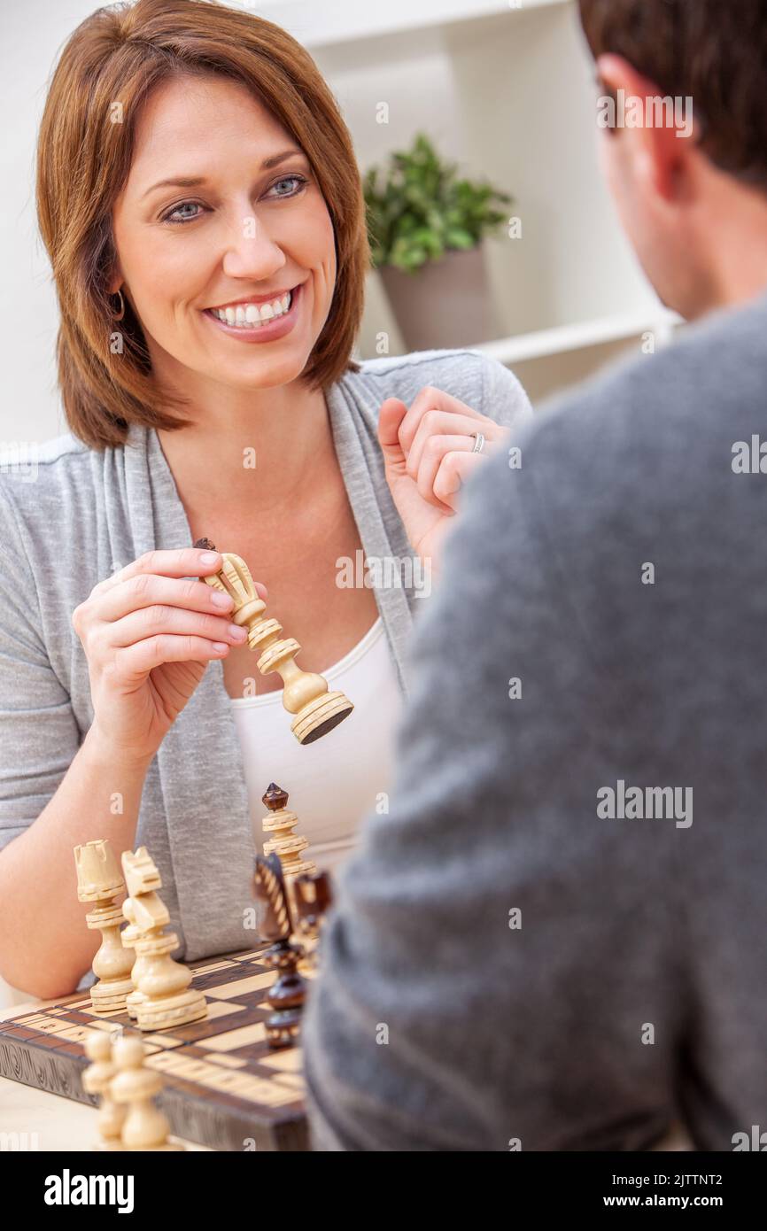 Froh, dass Mann und Frau Paar in den Dreißigern, Zusammensitzen im Hause Schach spielen Stockfoto