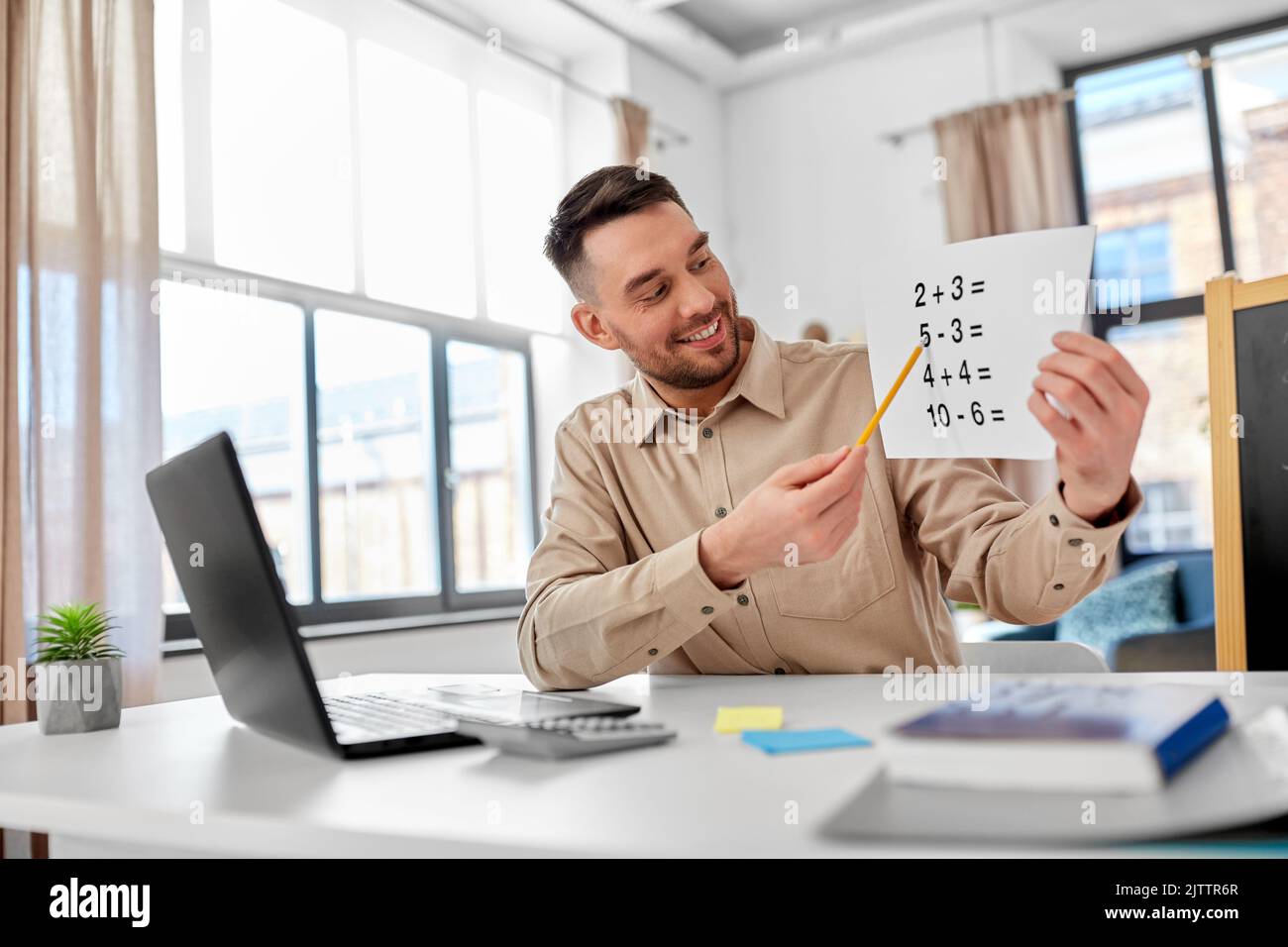 Männlicher Mathematiklehrer, der zu Hause Online-Unterricht hat Stockfoto
