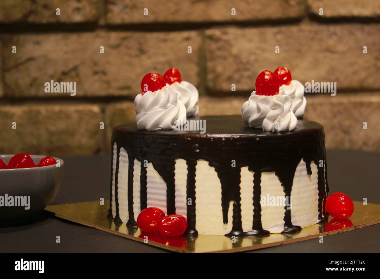 Schokoladen-Vanille-Kuchen mit Kirschen darauf Stockfoto