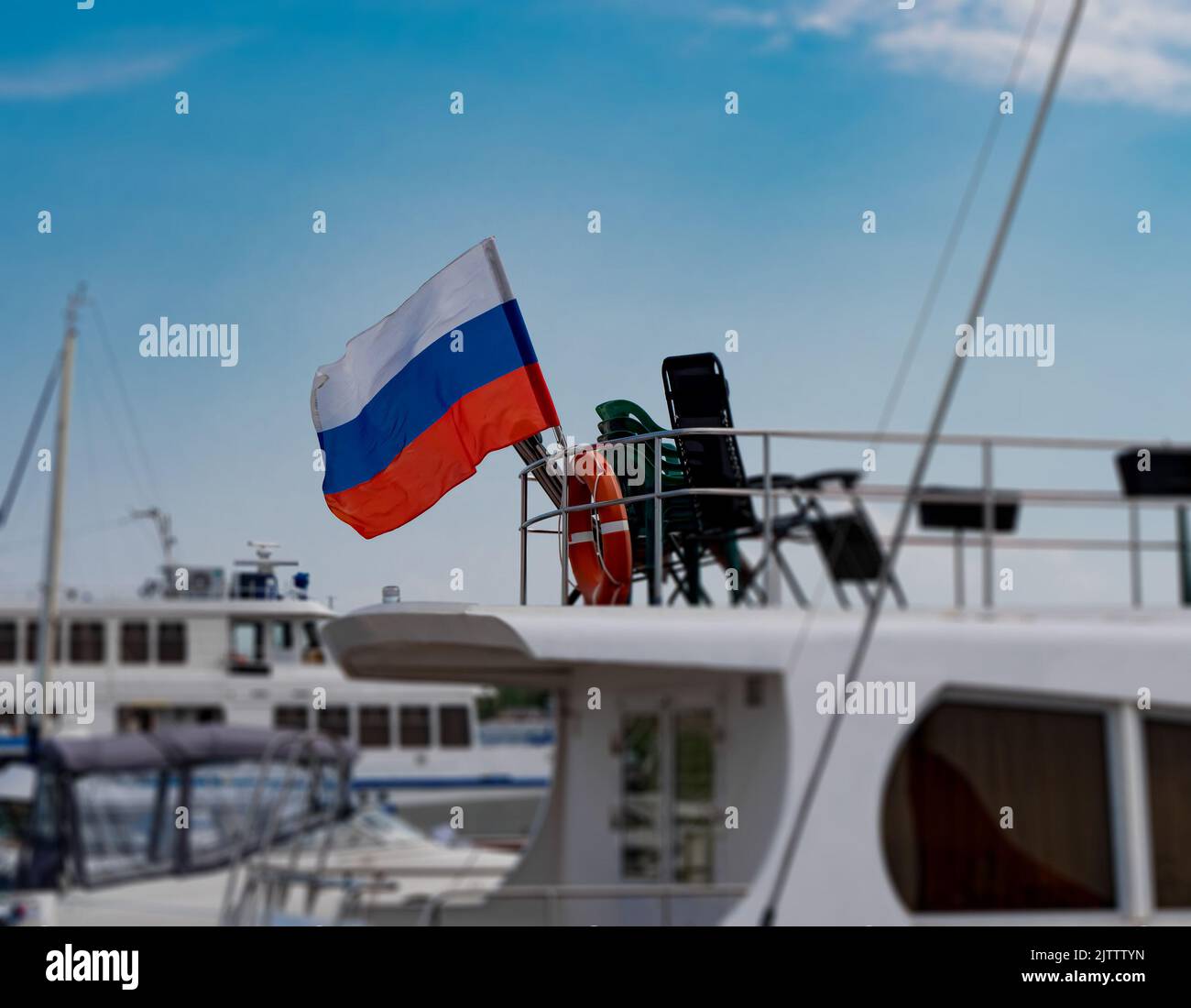 Die russische Flagge am Heck der Yacht. Große weiße Yacht im Hafen Stockfoto