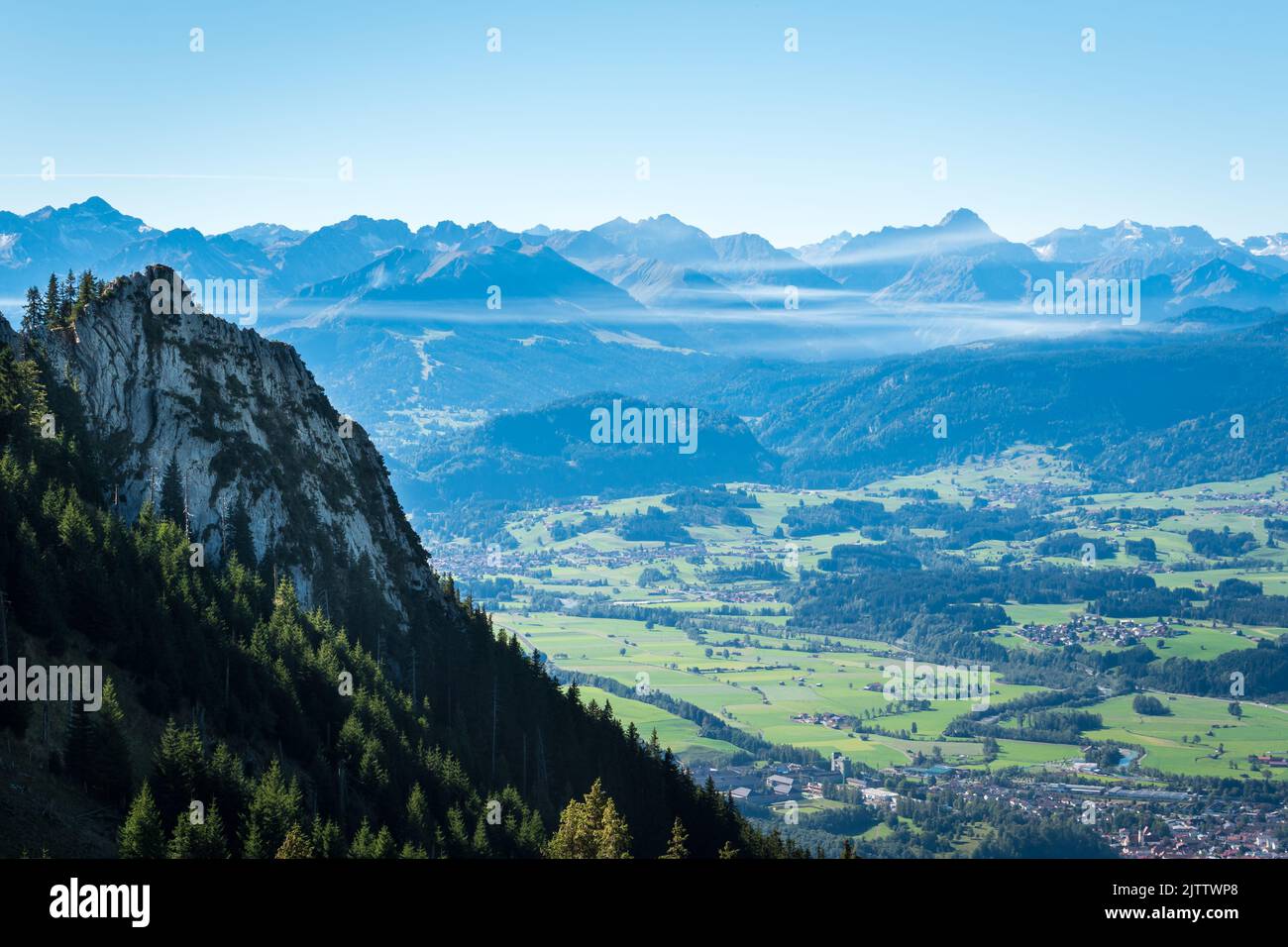Eine Luftaufnahme einer unberührten alpinen Landschaft mit Bergen und Städten am Fuß Stockfoto