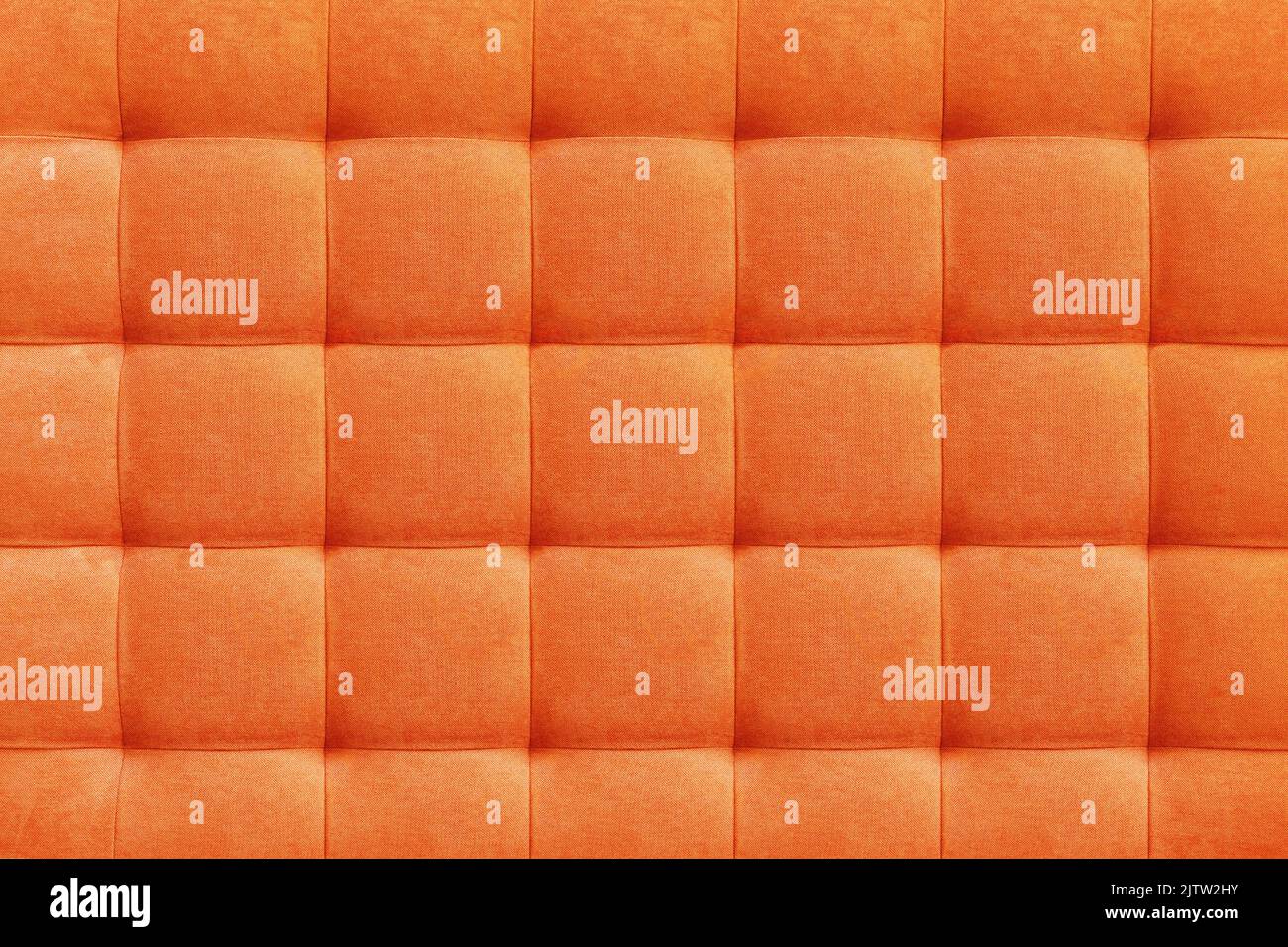 Orangefarbener Veloursleder-Hintergrund für die Wand im Raum. Interior Design, Kopfteile aus Möbelstoff, Möbelpolsterung. Klassischer Checkereklassiker Stockfoto