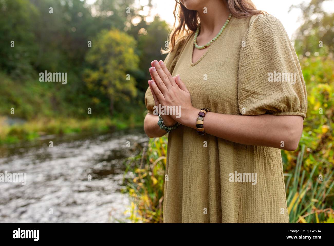 Frau oder Hexe, die ein magisches Ritual auf dem Fluss durchführt Stockfoto