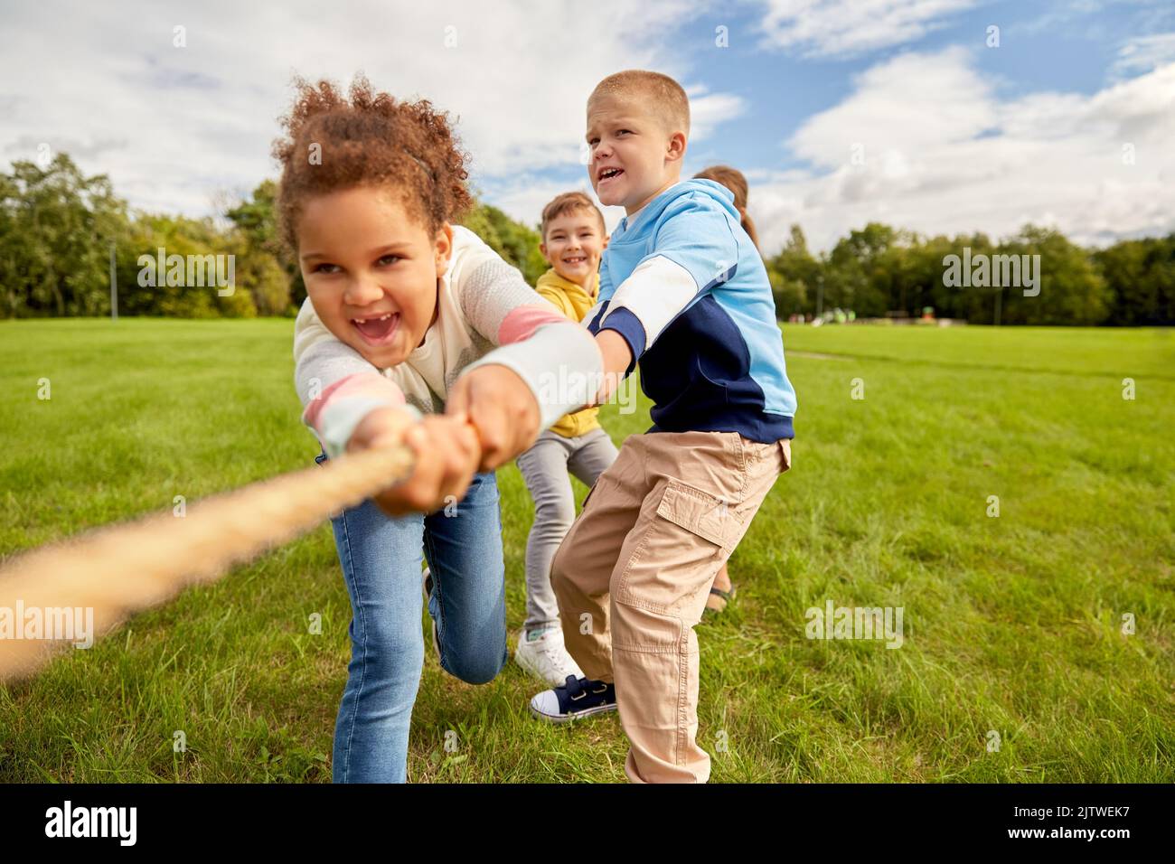Glückliche Kinder spielen Tauziehen Spiel im Park Stockfoto