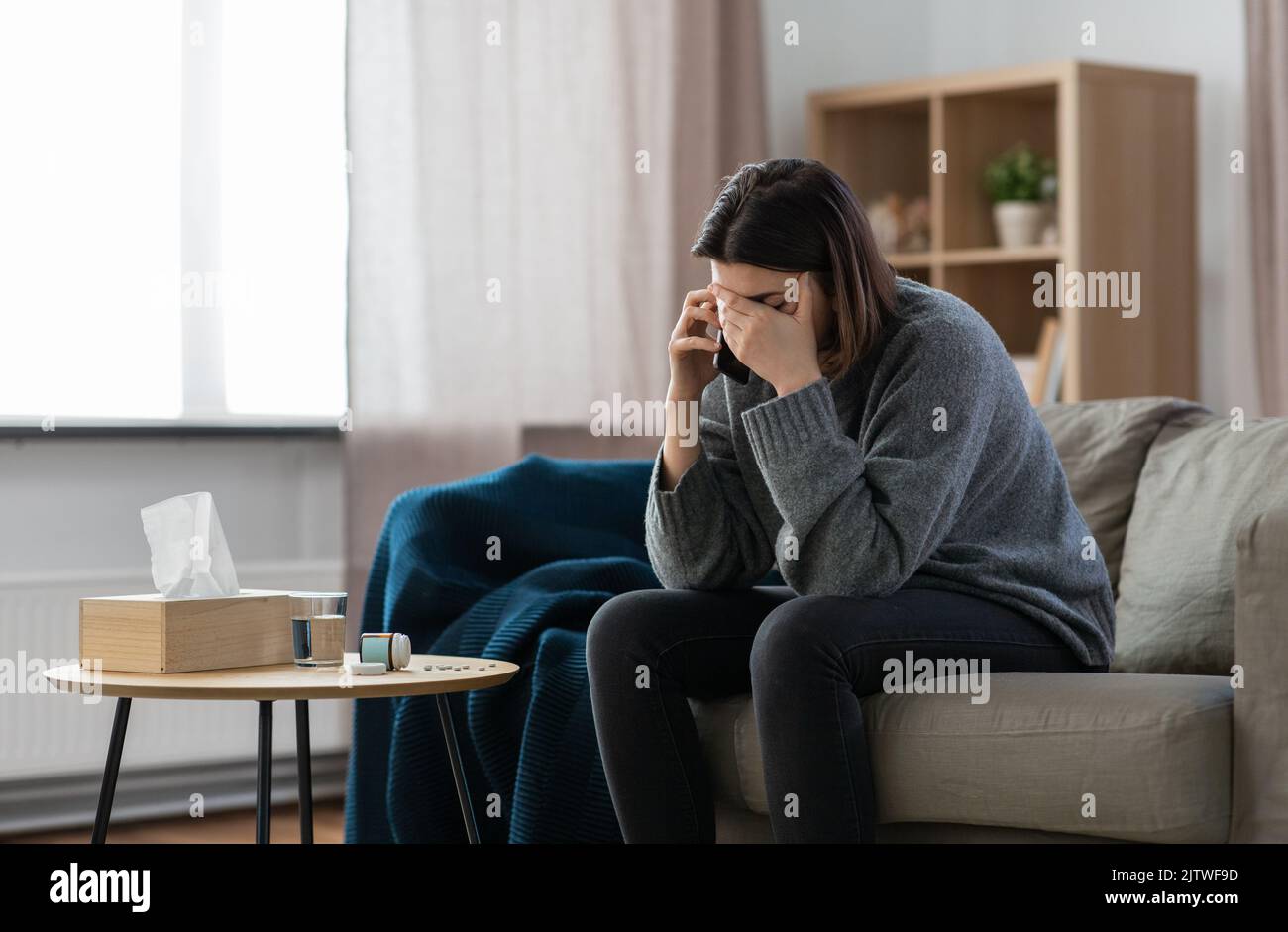 Gestresste Frau mit Medikamenten, die am Telefon anrufen Stockfoto
