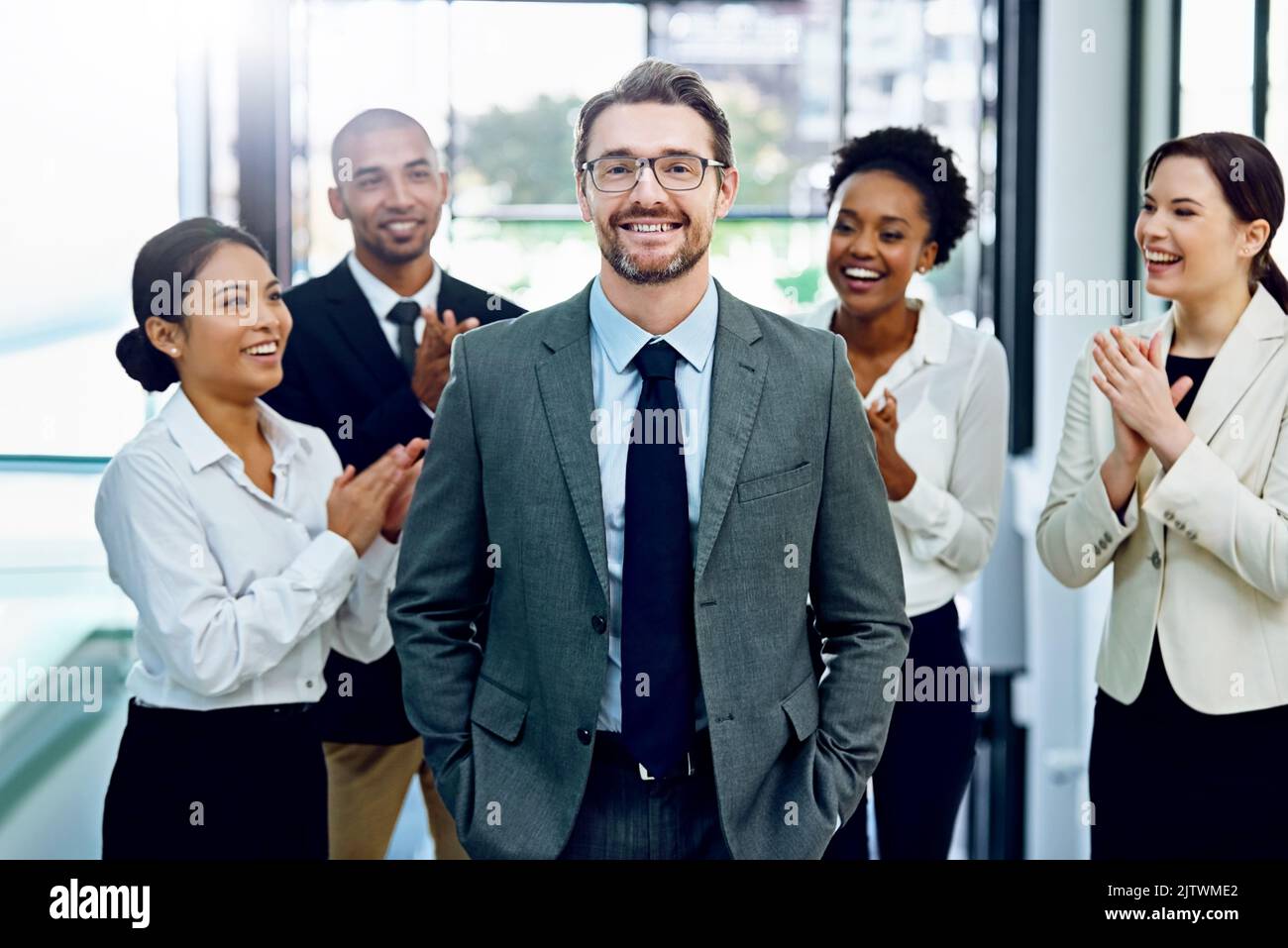 Ihre Wertschätzung für einen Job zeigen Gut gemacht. Porträt eines erfolgreichen Geschäftsmannes, der von seinen Kollegen im Büro applaudiert wird. Stockfoto