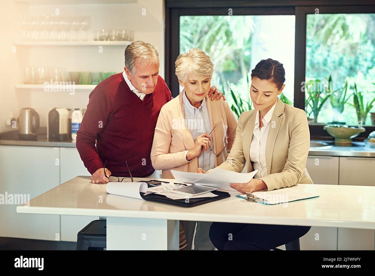 Unterstützung bei der Bekämpfung finanzieller Hindernisse. Ein Senior-Paar erhält Rat von ihrem Finanzberater. Stockfoto