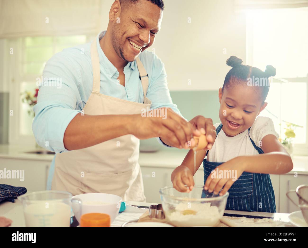 Vater, Lernende Mädchen oder Backen in der heimischen Küche und Kochen ein Kind Kuchen, Dessert oder Frühstück Cookies. Lustige, fröhliche und komische Kind mit Lächeln in Stockfoto