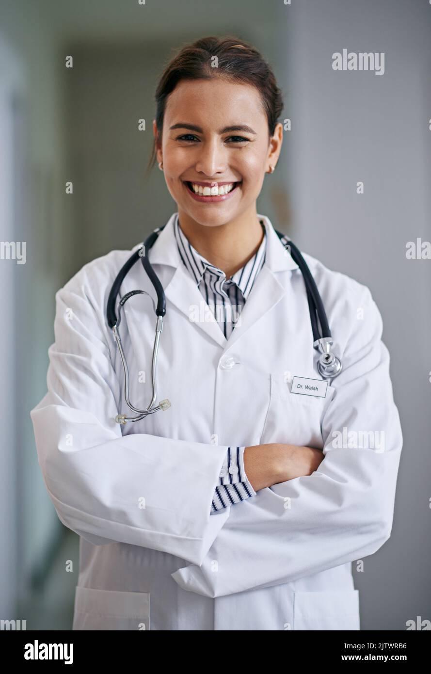 Der Arzt wird Sie jetzt sehen. Porträt einer fröhlichen und selbstbewussten jungen Ärztin, die ihre Arme kreuzt. Stockfoto