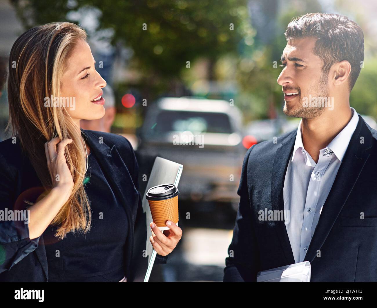 Frische Luft und freundliches Geschwätz auf ihrer Pause draußen. Zwei Kollegen aus dem Unternehmen, die eine Diskussion, während sie die Straße hinunter. Stockfoto