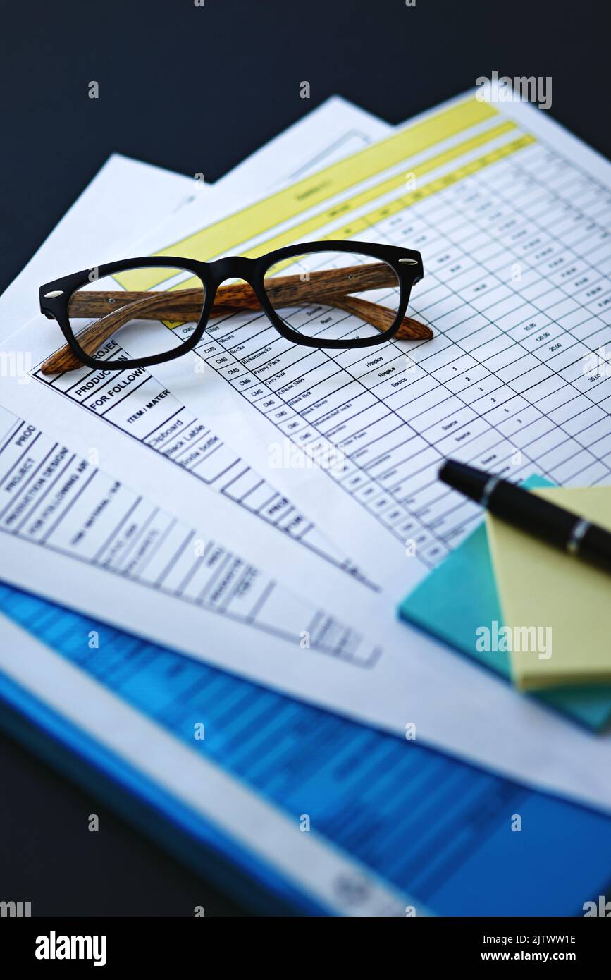 Zeit, diese Unterlagen durchzulesen. Nahaufnahme von Gläsern, die auf dem Papierkram sitzen. Stockfoto