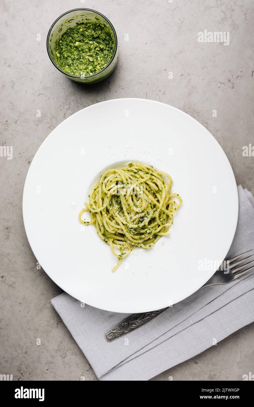 Spaghetti mit Pesto-Sauce auf weißem Teller, Draufsicht. Stockfoto