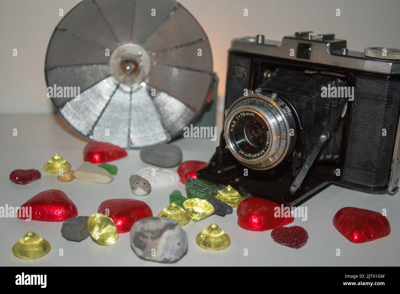 Bild einer alten Kamera mit Lampenblitz und verschiedenen Dekorationen. Stockfoto