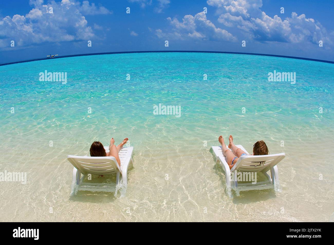 Urlauber entspannen auf Sonnenliegen in der Lagune der maledivischen Insel Biyadhoo, Süd-Male Atoll, Malediven, Indischer Ozean, Asien Stockfoto