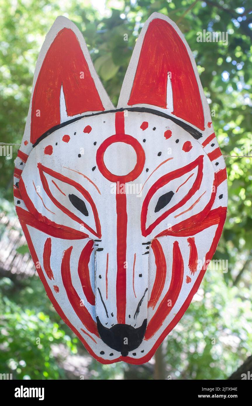 Carboard Kitsune Maske hängt am Seil. Japanesse Kultur Handwerk Workshop Konzept. Stockfoto