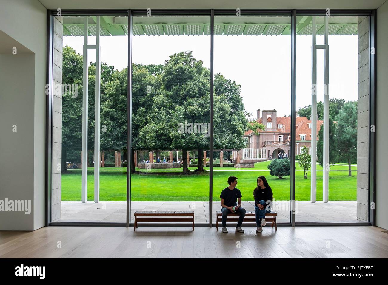 Ehepaar, das auf einer Bank im Museum Voorlinden, Niederlande, sitzt. Stockfoto