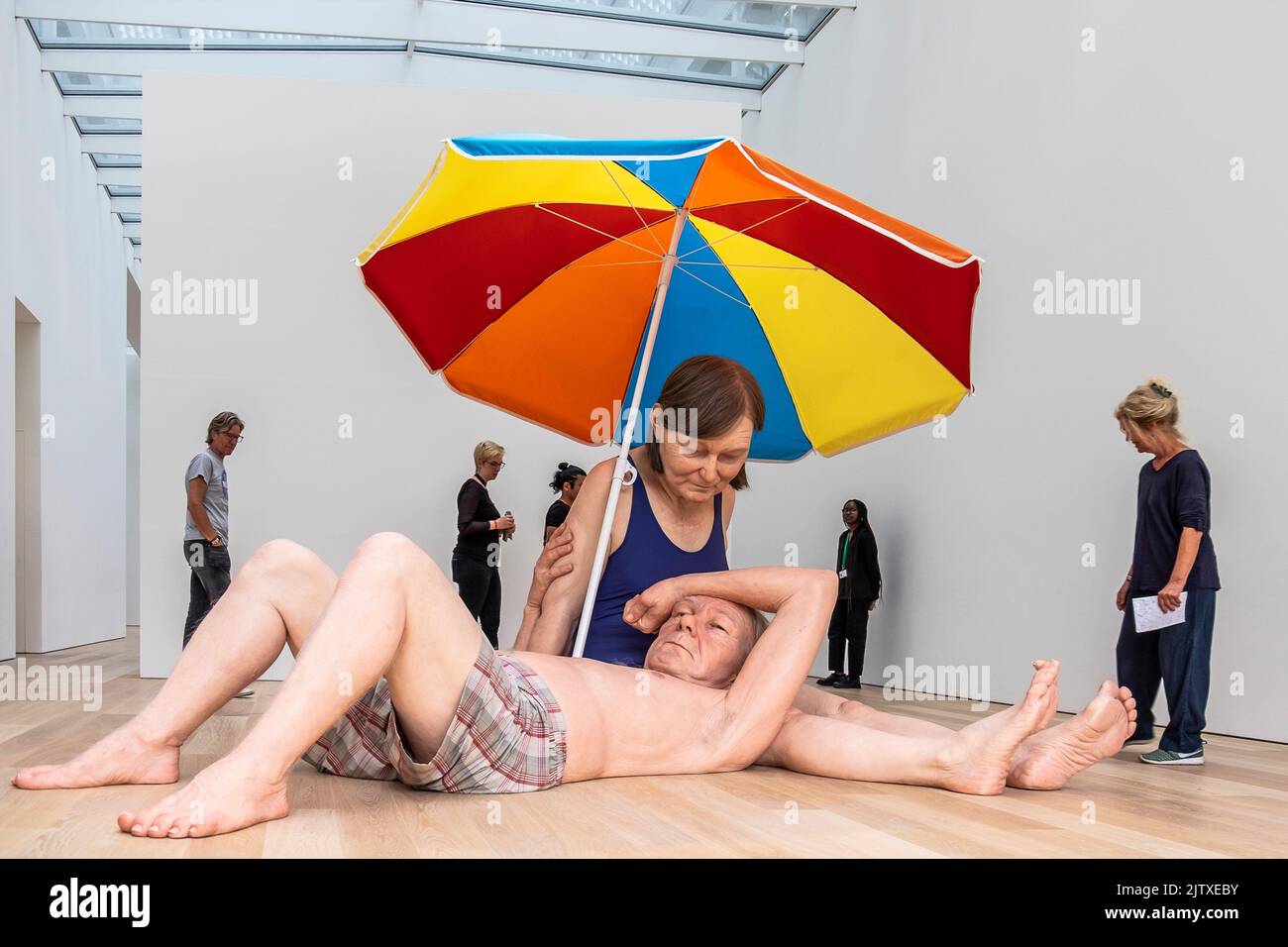 Besucher genießen die Skulptur „Paar unter einem Regenschirm“ von Ron Mueck im Museum Voorlinden, Niederlande. Stockfoto