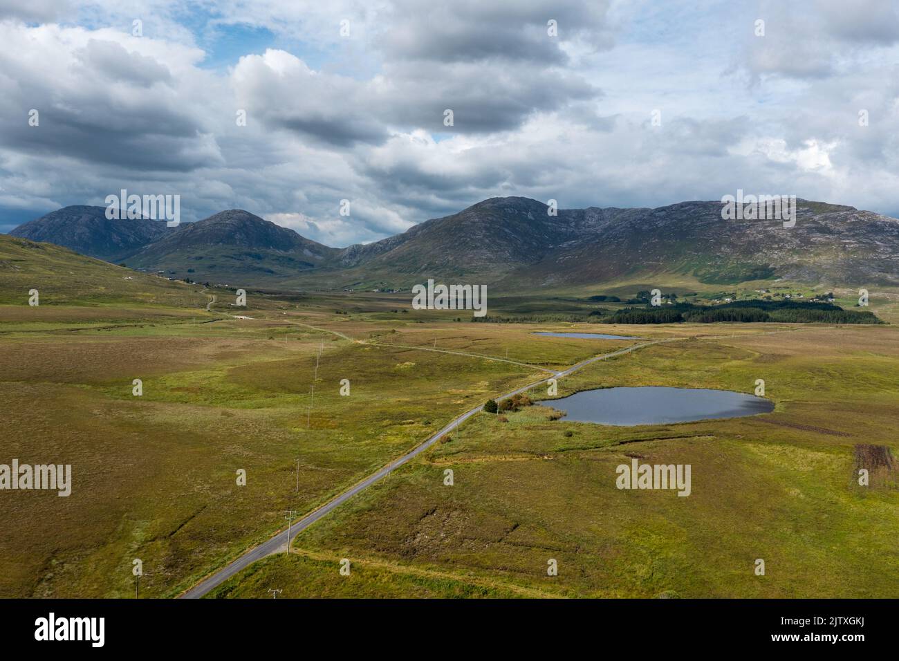 Die schmale Landstraße führt in die wilde Landschaft des Connemara-Nationalparks im Westen Irlands Stockfoto