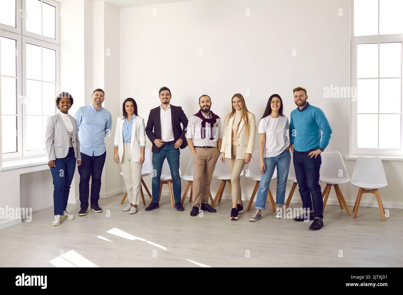 Lächelnde, multiethnische Mitarbeiter posieren gemeinsam im Büro Stockfoto