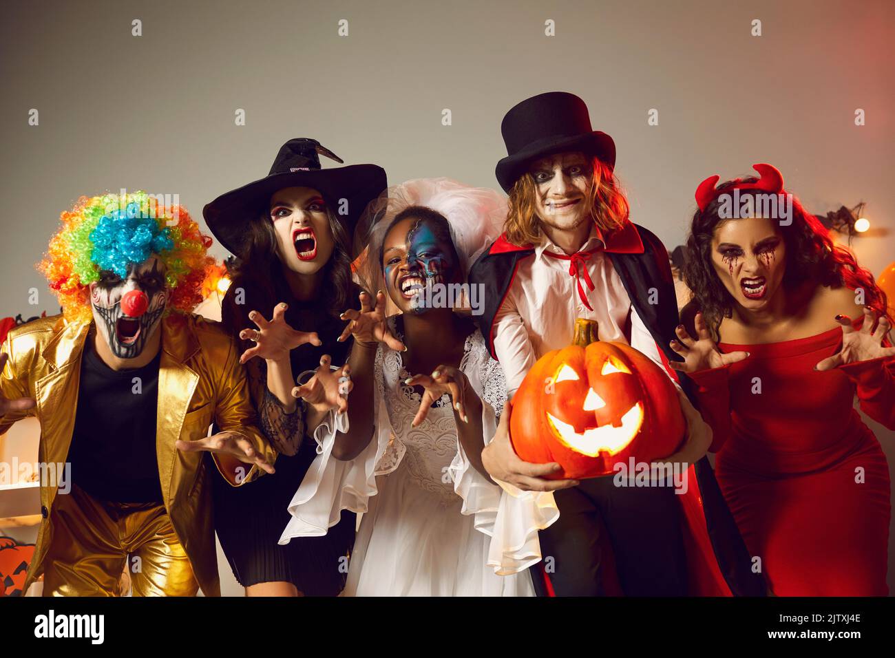 Eine Gruppe von Menschen, die in gruselige festliche Kostüme gekleidet sind und Spaß auf der Halloween-Party haben Stockfoto