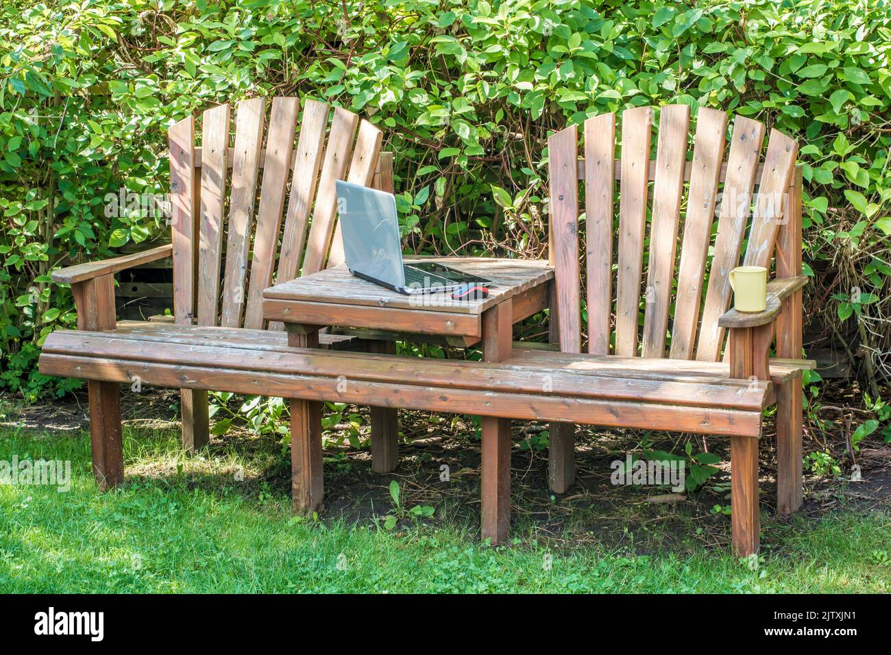 Home office im eigenen Garten mit Garten Bank und Laptop Stockfoto