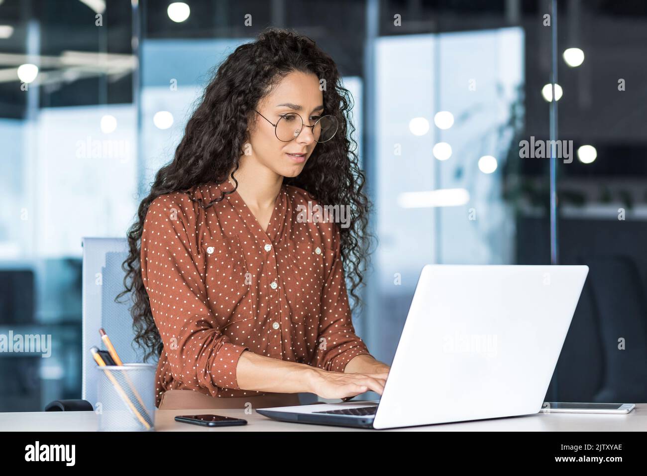 Schöne indische Frau Programmierer Web-Entwickler konzentriert und zuversichtlich arbeiten auf Laptop schreiben Code-Programmierung Business Frau Arbeiter in modernen Büro arbeiten in legerer Kleidung. Stockfoto