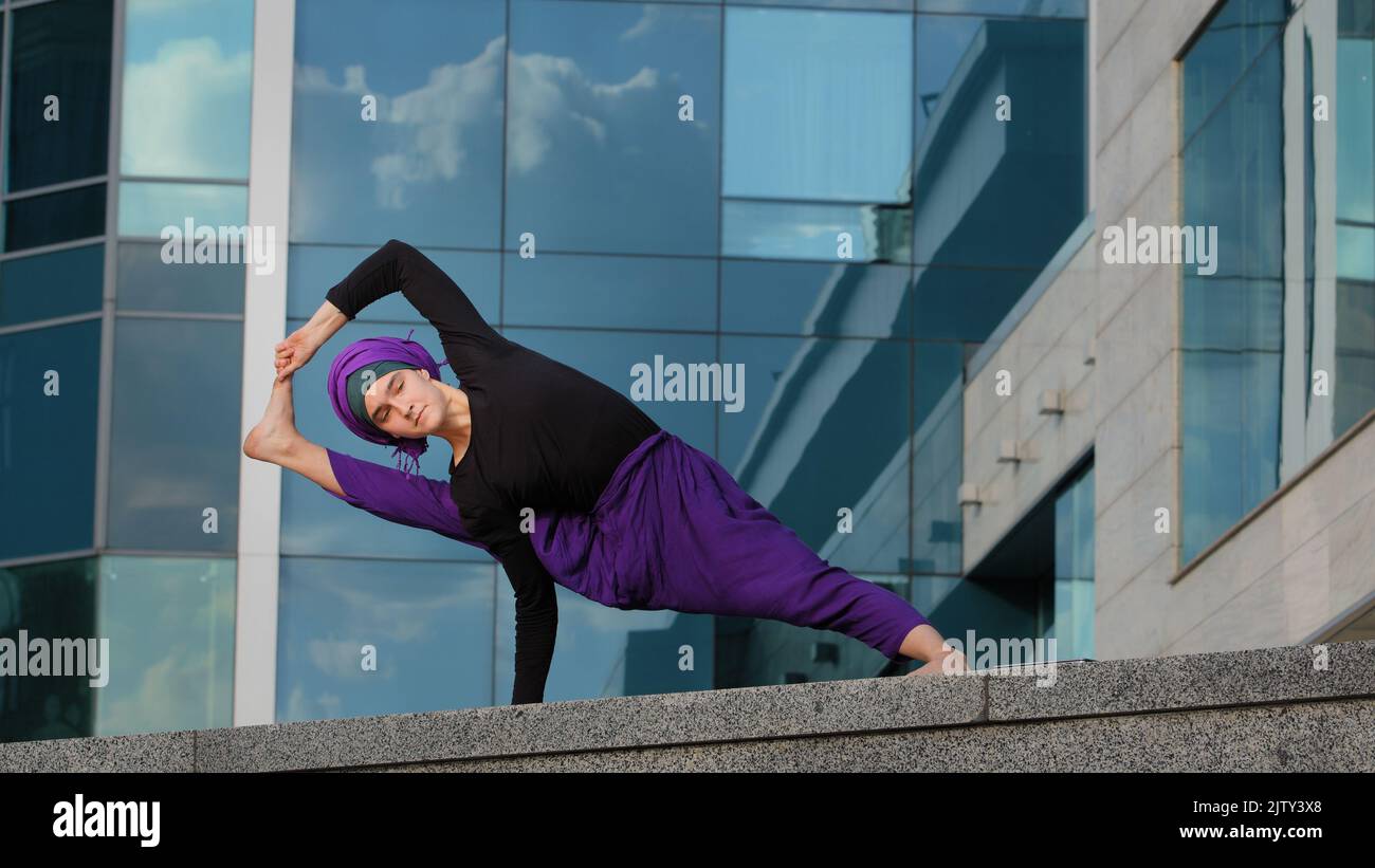 Starke Frau in Hijab Flexible Mädchen tun Yoga-Übungen auf Straße Stadt Gebäude Hintergrund Sport Dame steht in der Seitenwand auf einer Hand dehnt Körper Stockfoto