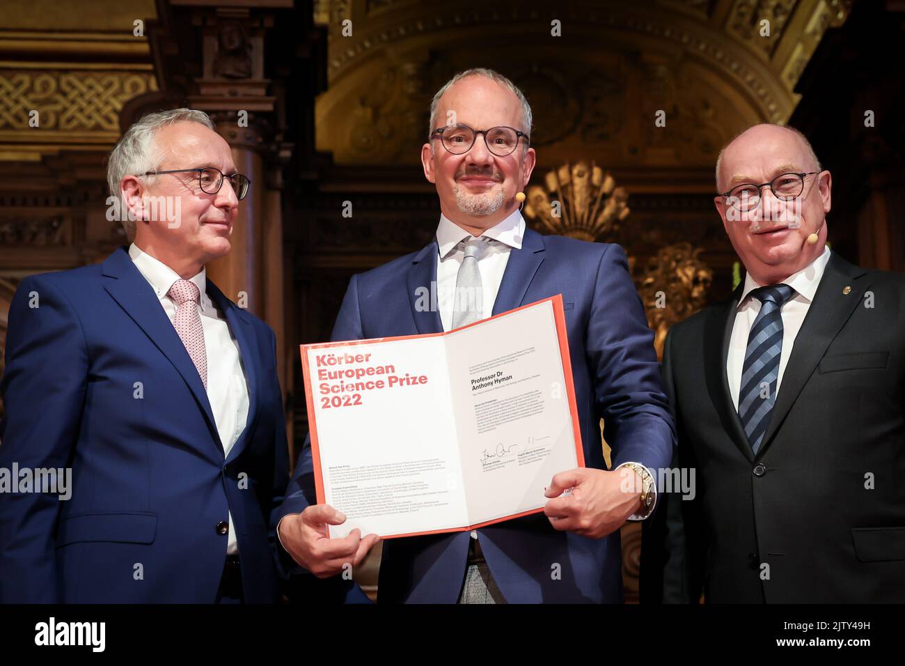 02. September 2022, Hamburg: Anthony Hyman (m), britischer Zellbiologe, steht mit seiner Auszeichnung zwischen Lothar Dittmer (l.), Vorsitzender des Vorstands der Körber-Stiftung, Und Martin Stratmann, Präsident der Max-Planck-Gesellschaft und Vorsitzender des Kuratoriums des Körber-Preises, nach Erhalt des Körber-Preises im Großen Ballsaal des Rathauses. Hyman, ein in Dresden forschender Zellbiologe, erhielt den mit einer Million Euro dotierten Körber-Preis für Europäische Wissenschaft. Der Brite wurde für Grundlagenforschung zu neurodegenerativen Erkrankungen wie Alzheimer geehrt. Stockfoto