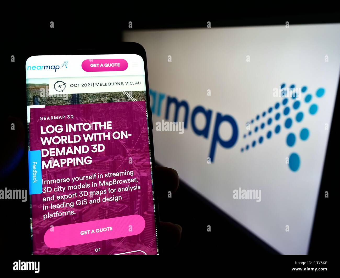Person, die Smartphone mit der Webseite des Luftbildunternehmens Nearmap Limited auf dem Bildschirm vor dem Logo hält. Konzentrieren Sie sich auf die Mitte des Telefondisplays. Stockfoto