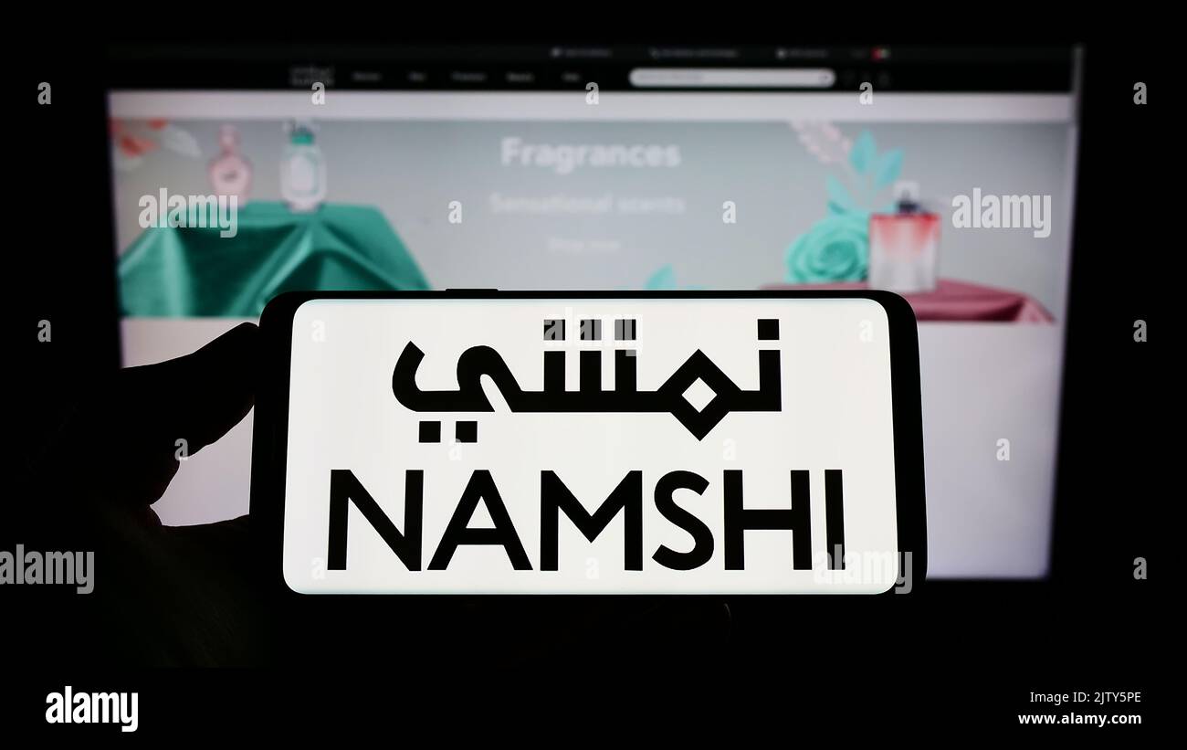 Person, die das Smartphone mit dem Logo des arabischen E-Commerce-Unternehmens Namshi auf dem Bildschirm vor der Website hält. Konzentrieren Sie sich auf die Telefonanzeige. Stockfoto