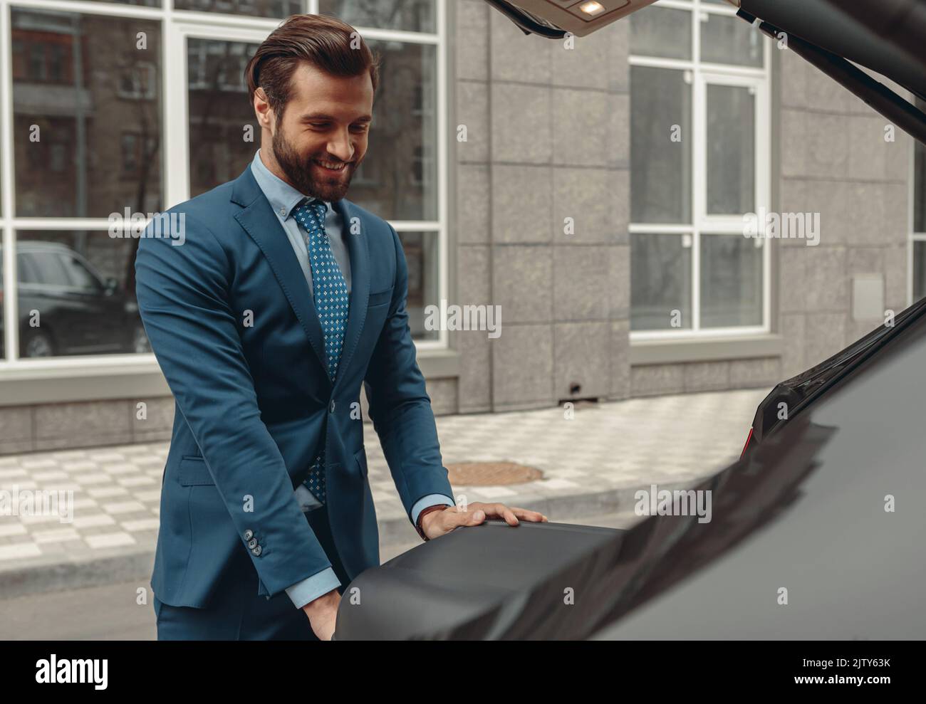 Vertrauen lächelnde Unternehmer in Anzug wird mit dem Auto reisen Stockfoto