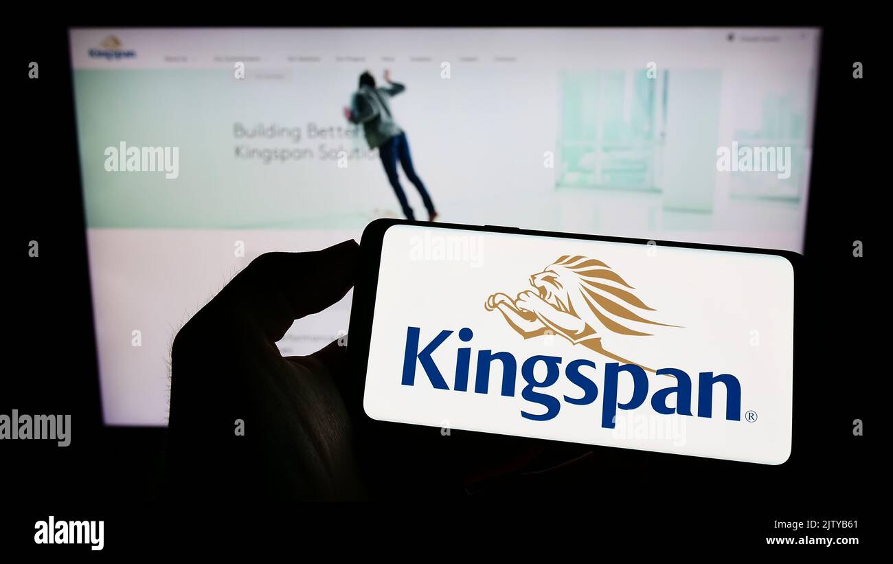 Person, die ein Smartphone mit dem Logo des Baustoffunternehmens Kingspan Group plc auf dem Bildschirm vor der Website hält. Konzentrieren Sie sich auf die Telefonanzeige. Stockfoto