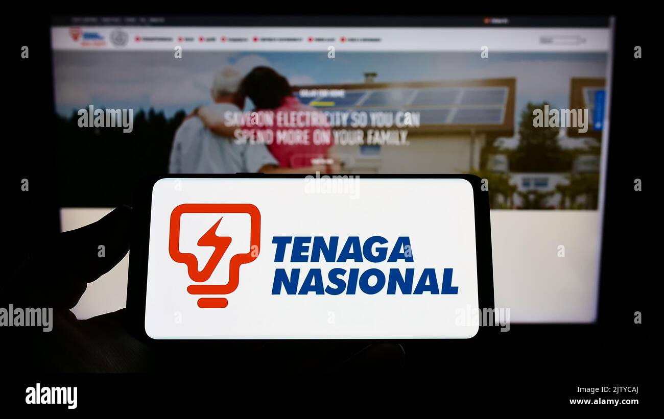 Person, die das Smartphone mit dem Logo des malaysischen Unternehmens Tenaga Nasional Berhad (TNB) auf dem Bildschirm vor der Website hält. Konzentrieren Sie sich auf die Telefonanzeige. Stockfoto