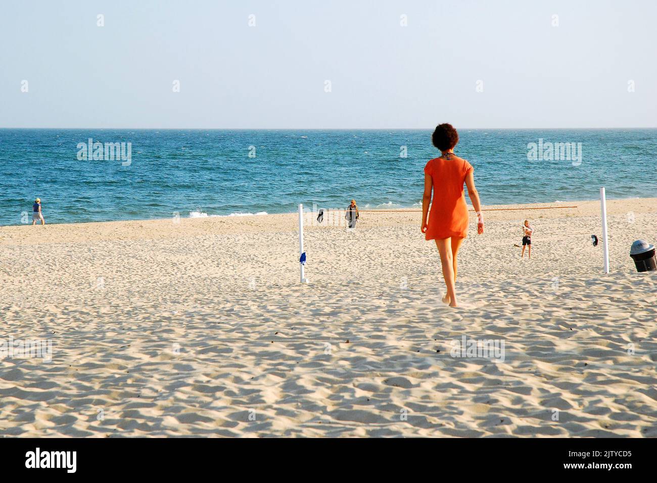 Eine Erwachsene Frau findet an einem sonnigen Sommerferientag Einsamkeit auf dem Sand des Main Beach von East Hampton in den Hamptons Stockfoto